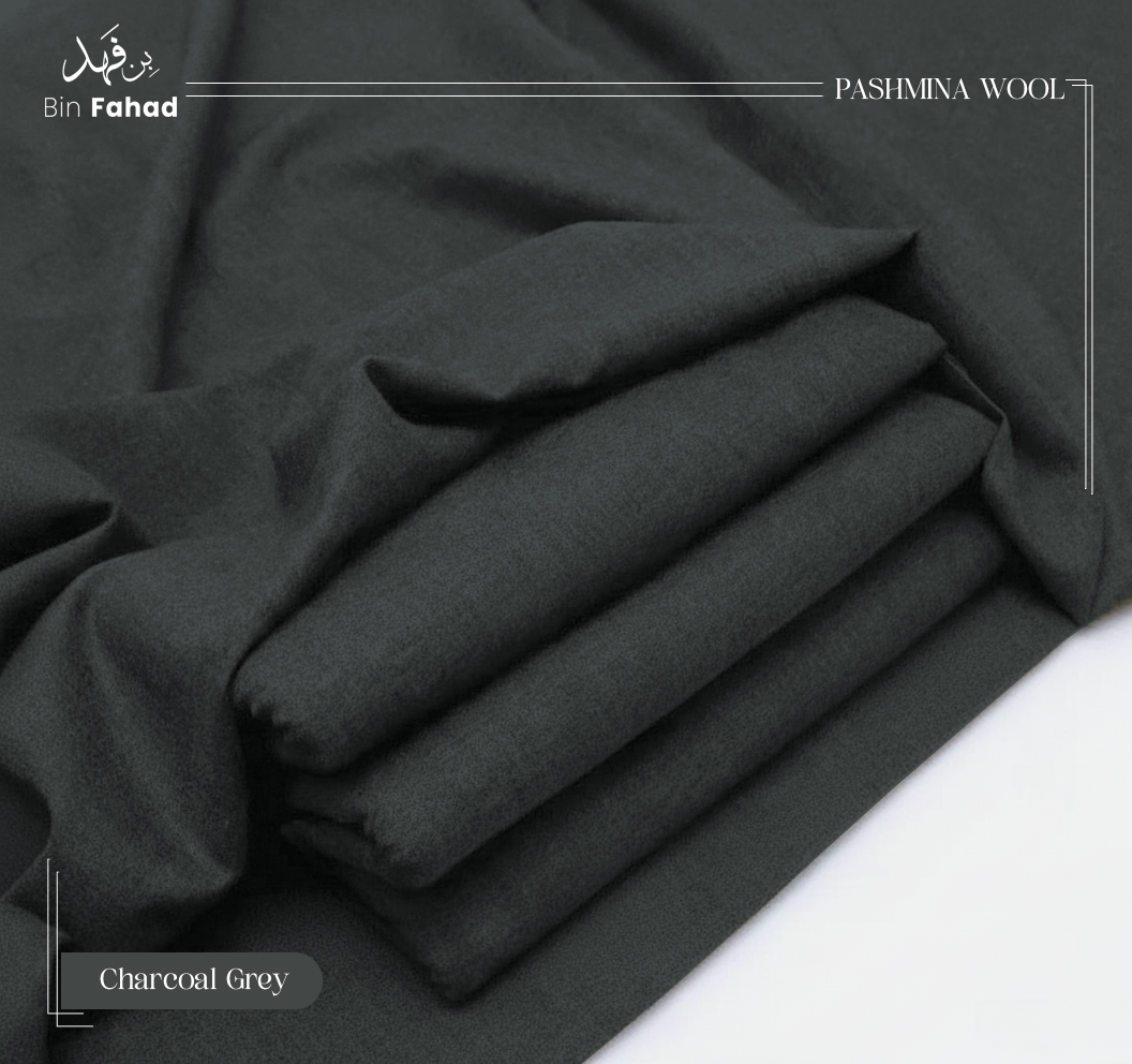 Folded charcoal grey pashmina wool fabric on a white background