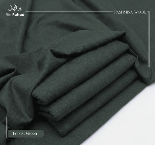 Folded forest green pashmina wool fabric on a white background